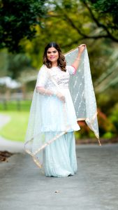 How to Choose Outfits You Can Wear on Different Occasions Smiling Indian woman in elegant saree posing outdoors on a sunny day.