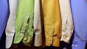 Smart Casual Style Guide for Women A row of vibrant, striped shirts hanging neatly, showcasing fashion variety.