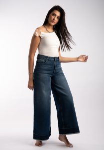 How to Choose Outfits You Can Wear on Different Occasions Elegant portrait of a woman in casual fashion showcasing wide-leg jeans and a white top.