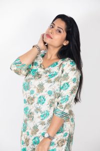 Portrait of a confident woman in a floral kurta on a light background. Perfect for fashion and lifestyle themes.